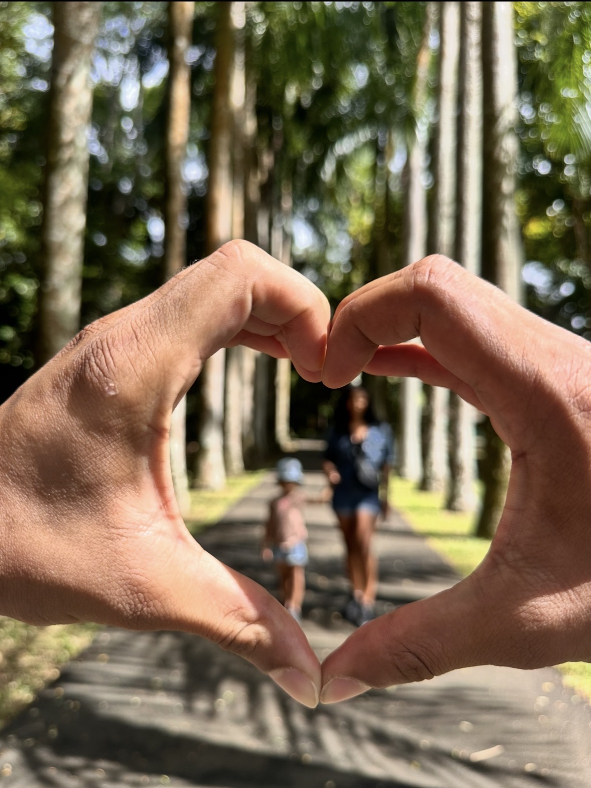 Un cœur formé avec les mains autour d'une maman et sa fille